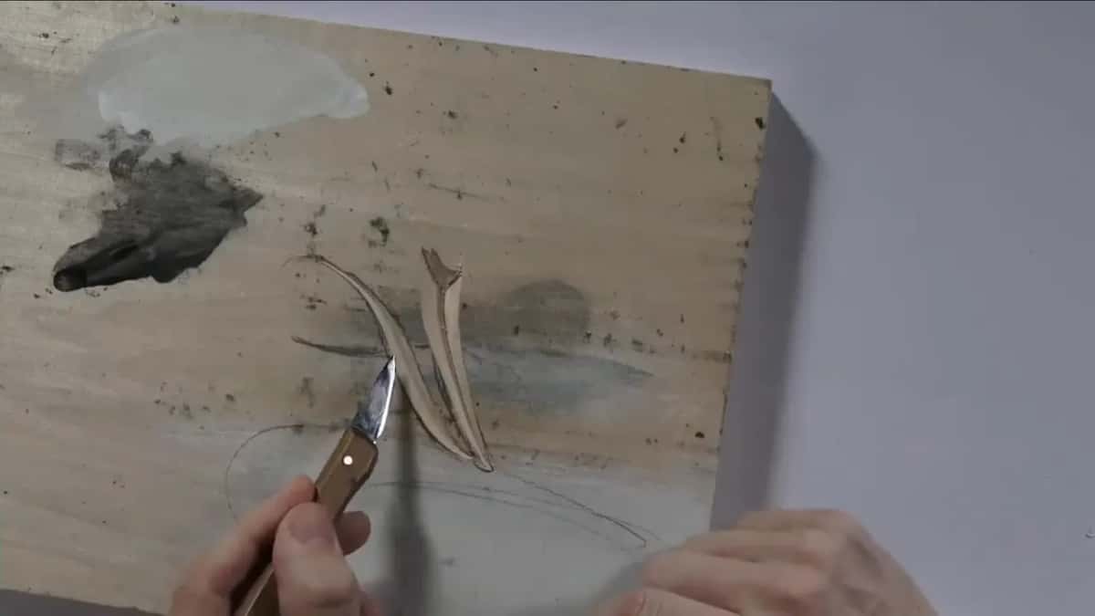Point of the knife below the carved strokes once the board was turned again