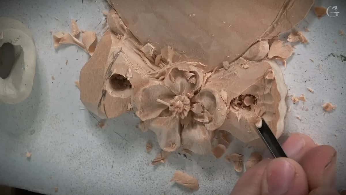 Narrow blade at the right side of a carved flower and bow, a few chips on the white board
