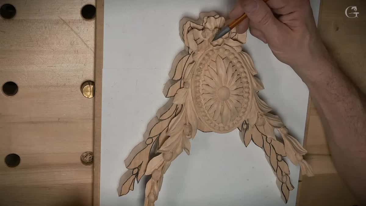 Carved oval rosette with leaf swags each side, black lines still on them, a pencil at the bow
