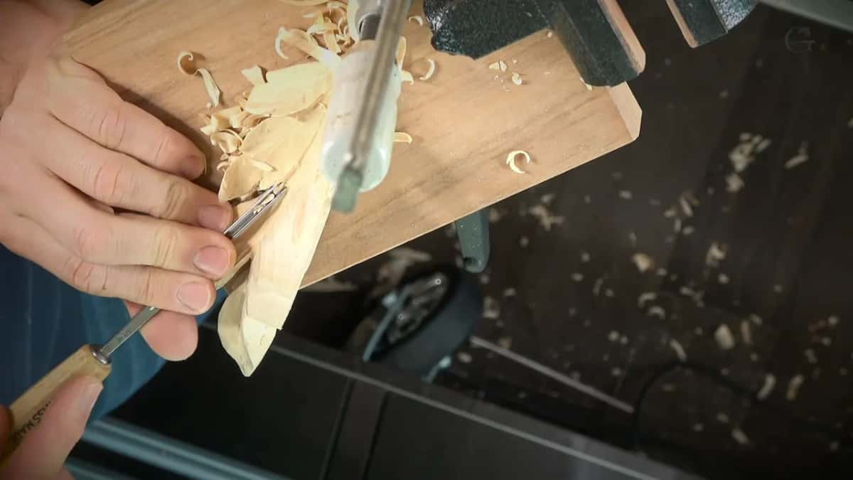 SWISS MADE printed along a pale handle, the narrow blade at the edge of a clamped leaf