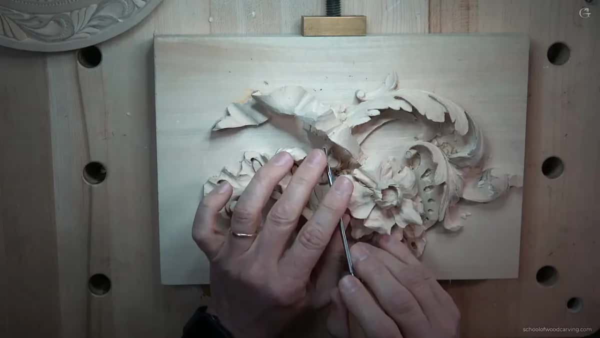 Both hands on a slim tool at the place where the top leaf turns down