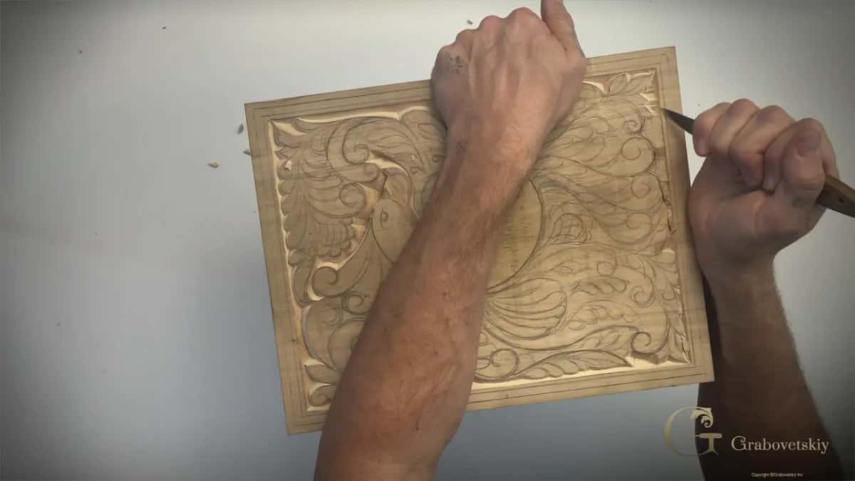 Left arm across the board while the knife works along its right side