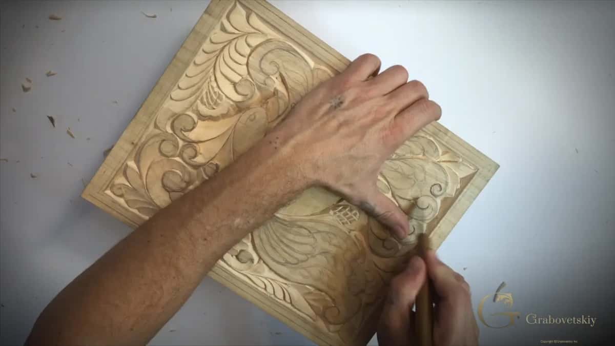 Diagonal board, left hand on top, knife held upright at the lower right