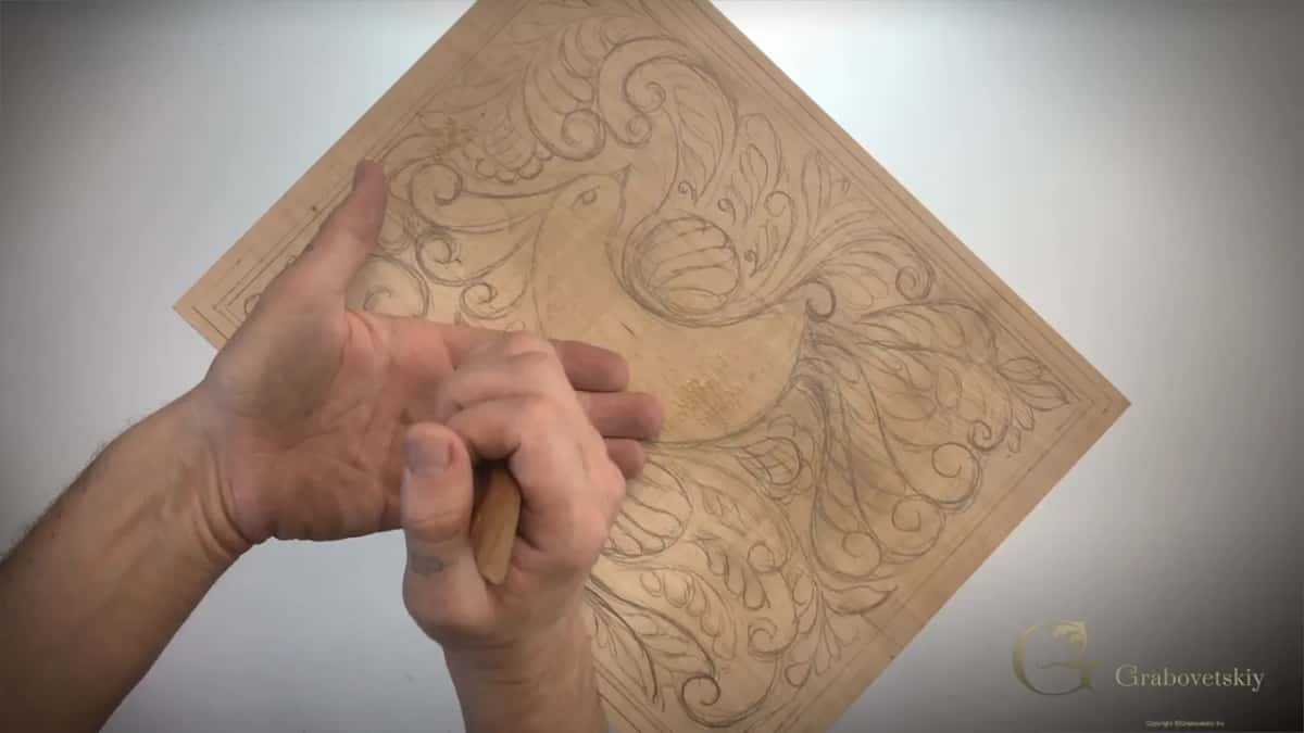 One hand low on the knife, the other raised open just above it