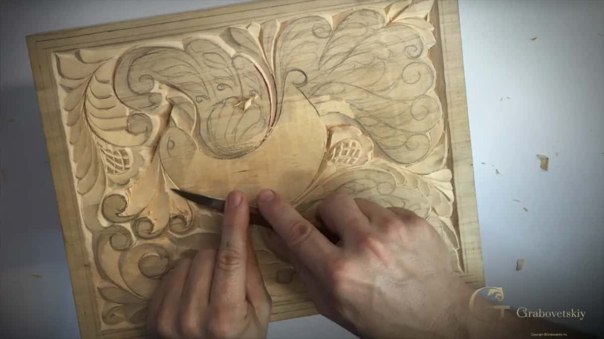 Low at the lower edge, both hands on the knife
