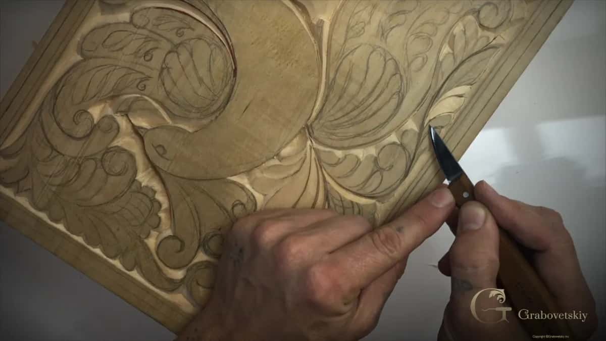 A forefinger pushes behind the blade at the right edge