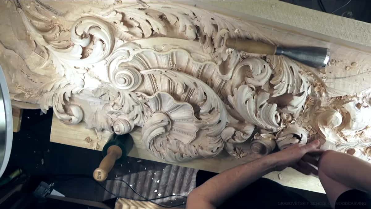 Big gouge across the relief while both hands rest near the front of the board.