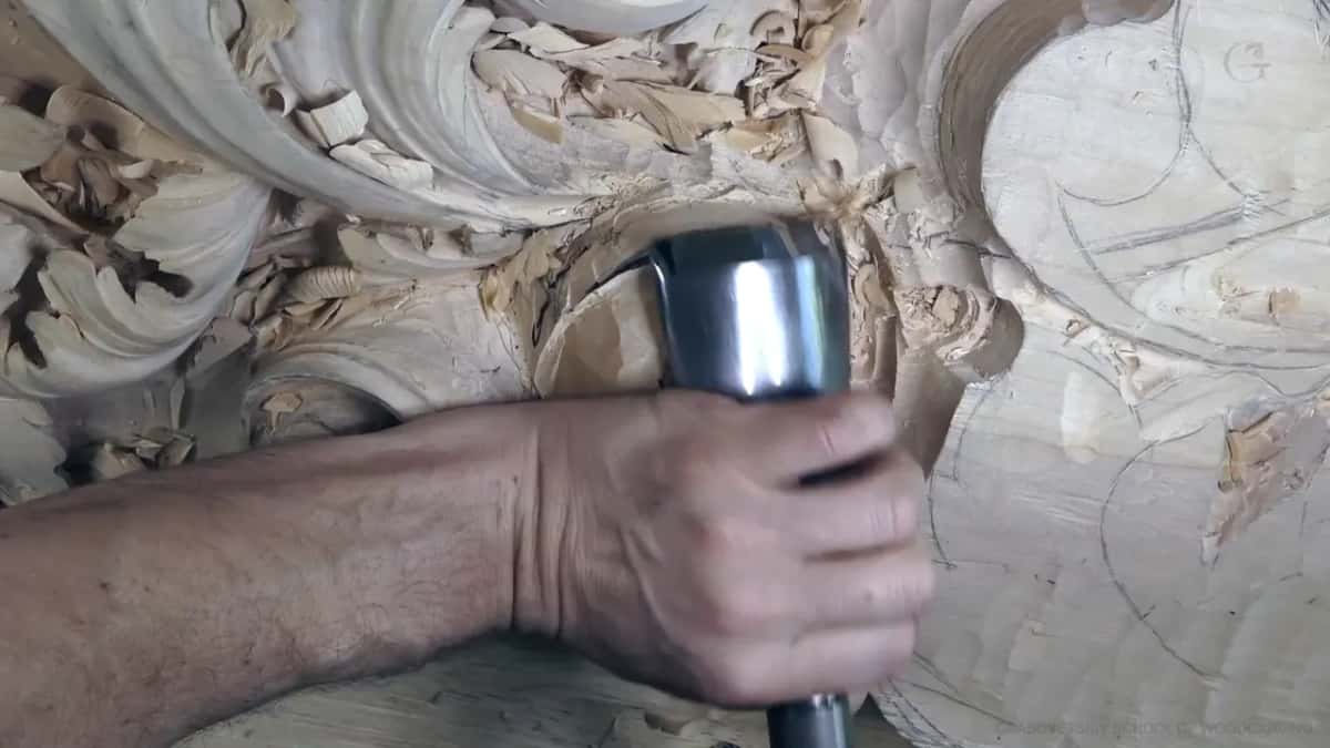 One fist around a big steel-ferruled gouge.