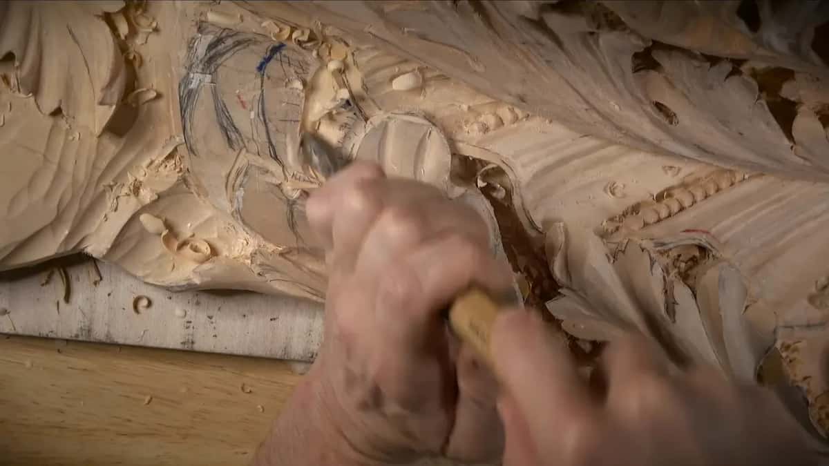 Blue and black pencil lines cover a lobe as both hands work