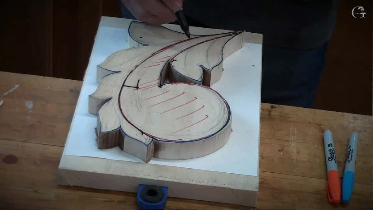 Black marker drawing lines over the top layer, where red hatching has already gone on