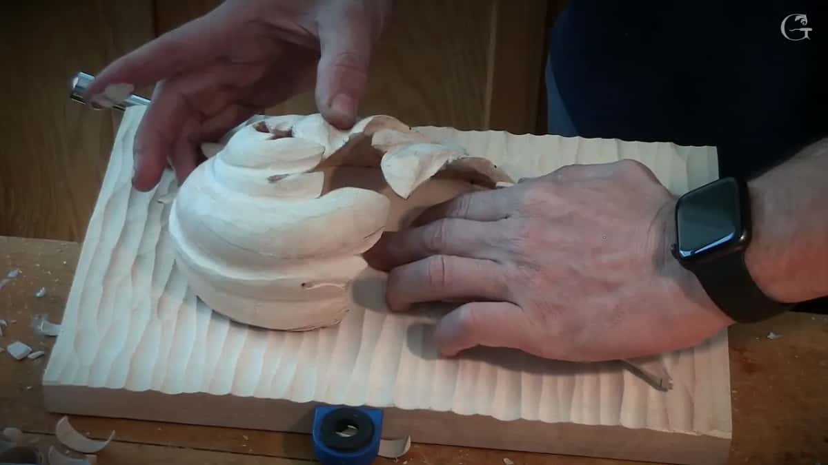 Both hands on the leaf as it sits on the board