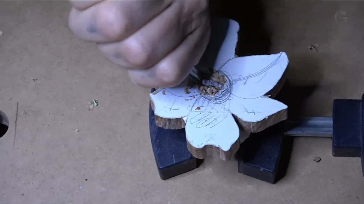 Flower blank held in a clamp, its paper pattern still on