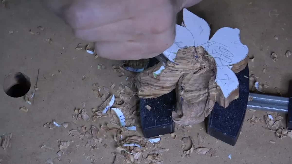 Olive petals curling up out of the blank, paper still on the uncarved ones