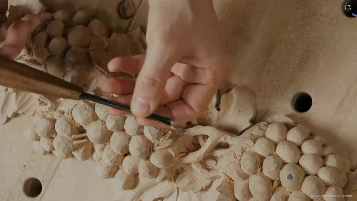 Both hands on the gouge, working in the middle of the fruit