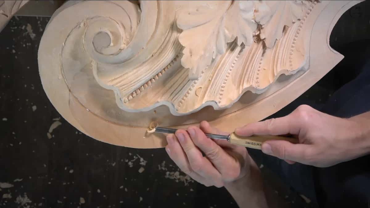 A curl lifts out of the groove ahead of a Swiss made gouge.