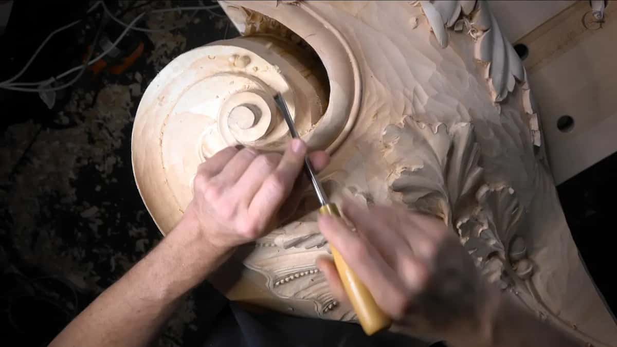 Knuckles low, the gouge follows the round of the scroll.