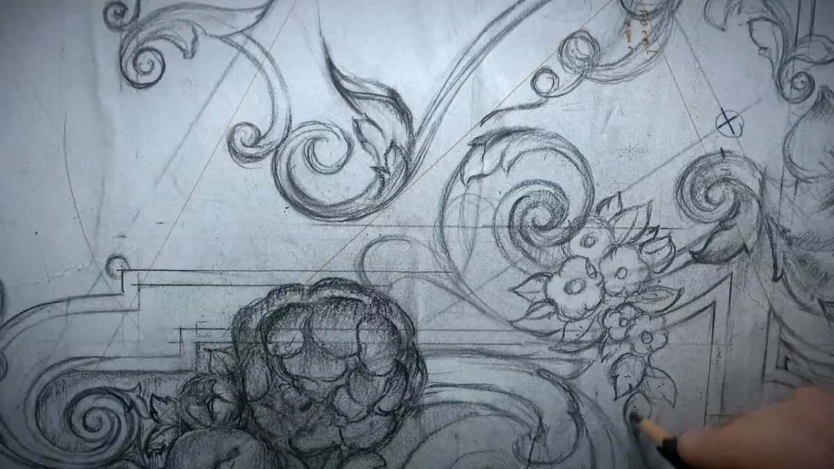 Small flowers bunched between the scrolls, a circled cross above them and a pencil tip at the right