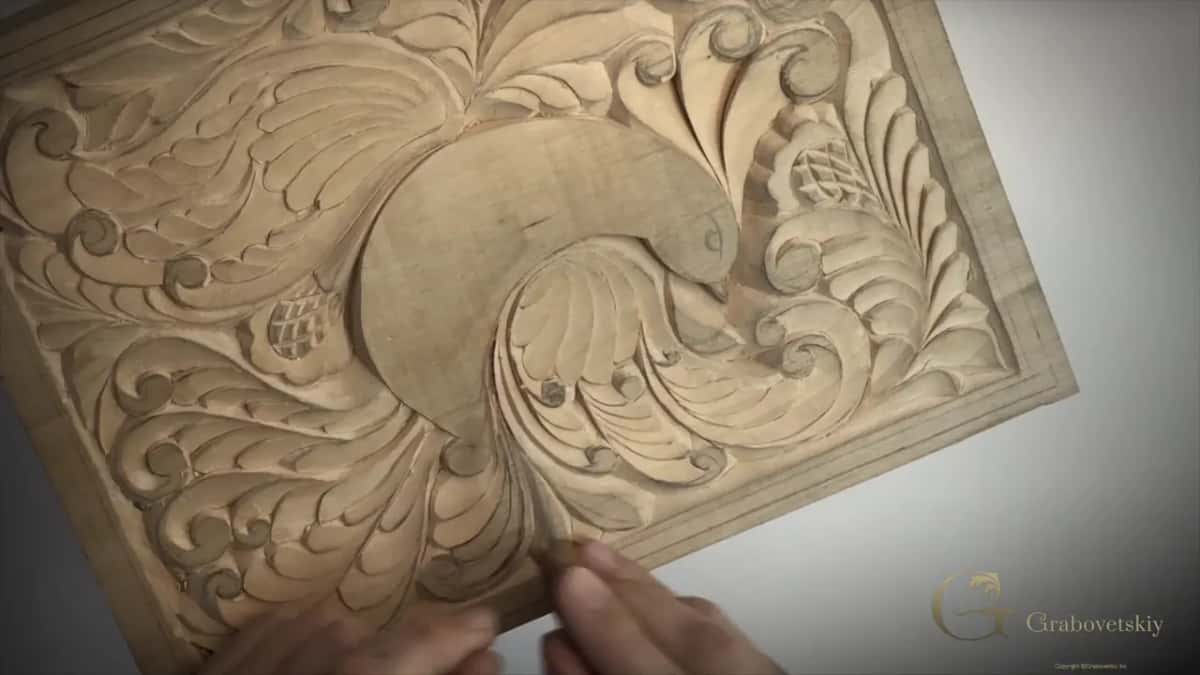 Carved board tipped up toward the camera, and a few of my fingertips resting along its bottom edge