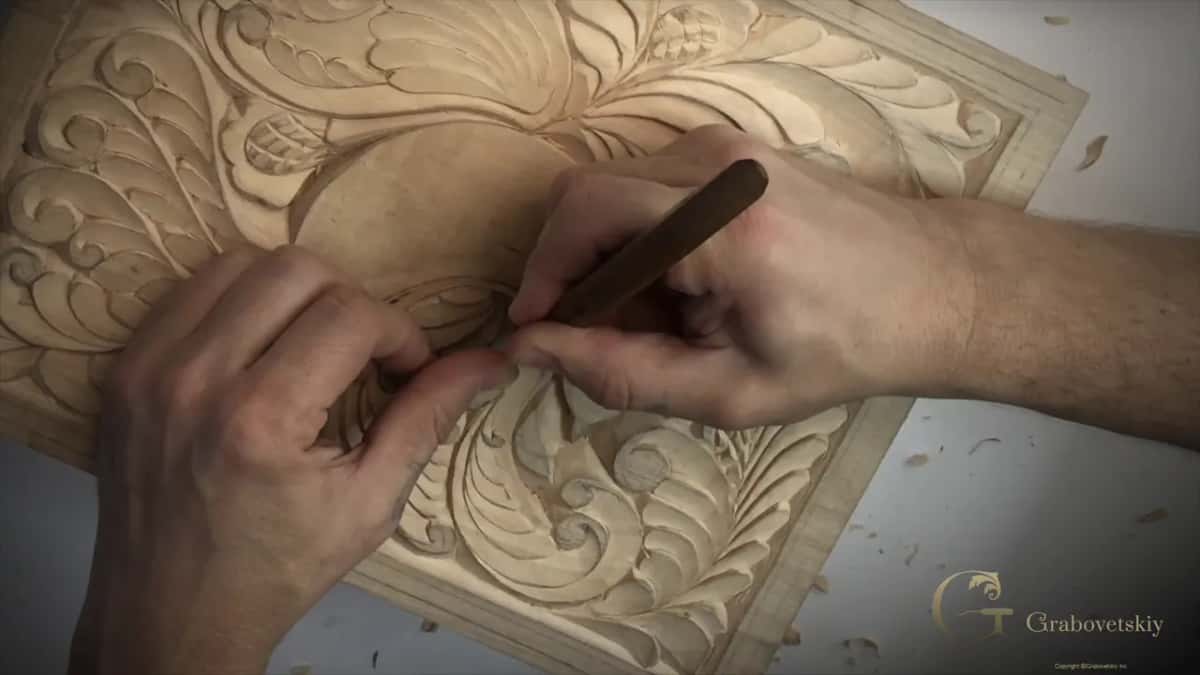 Both hands meet over the middle of a curl, holding a dark-handled knife like a pen