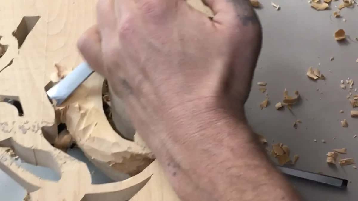 Fist wrapped round a tool, steel pressed into the bare back