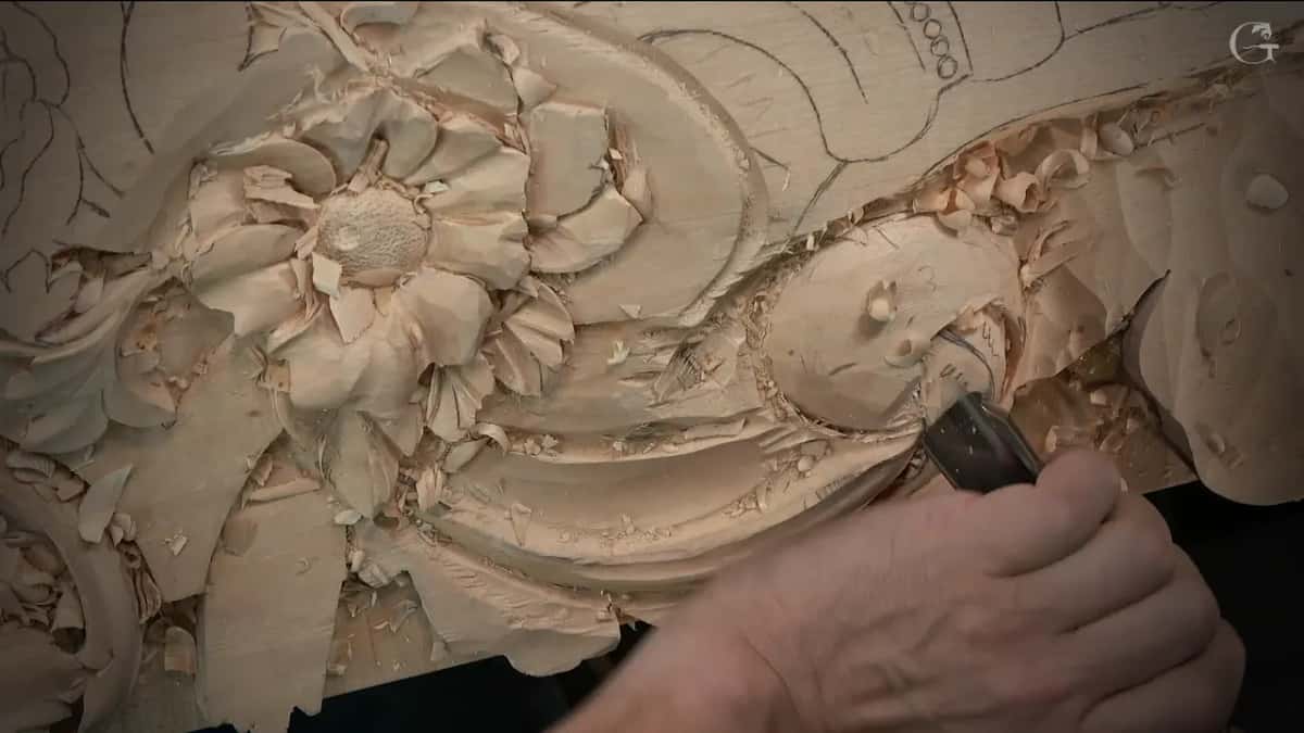 Wide gouge resting in the long section, a flower with a punched centre at the upper left of the frame