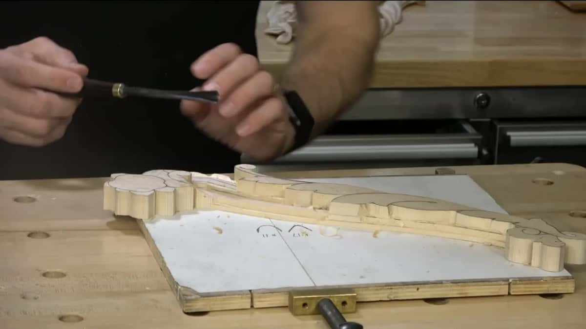 Both hands on a long dark handle above the board, the tool held level.