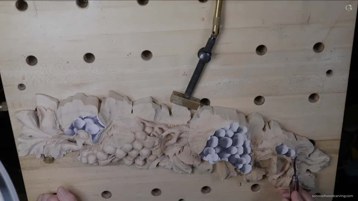 Seen from above, the whole long panel on the bench, with two hands resting at its lower edge