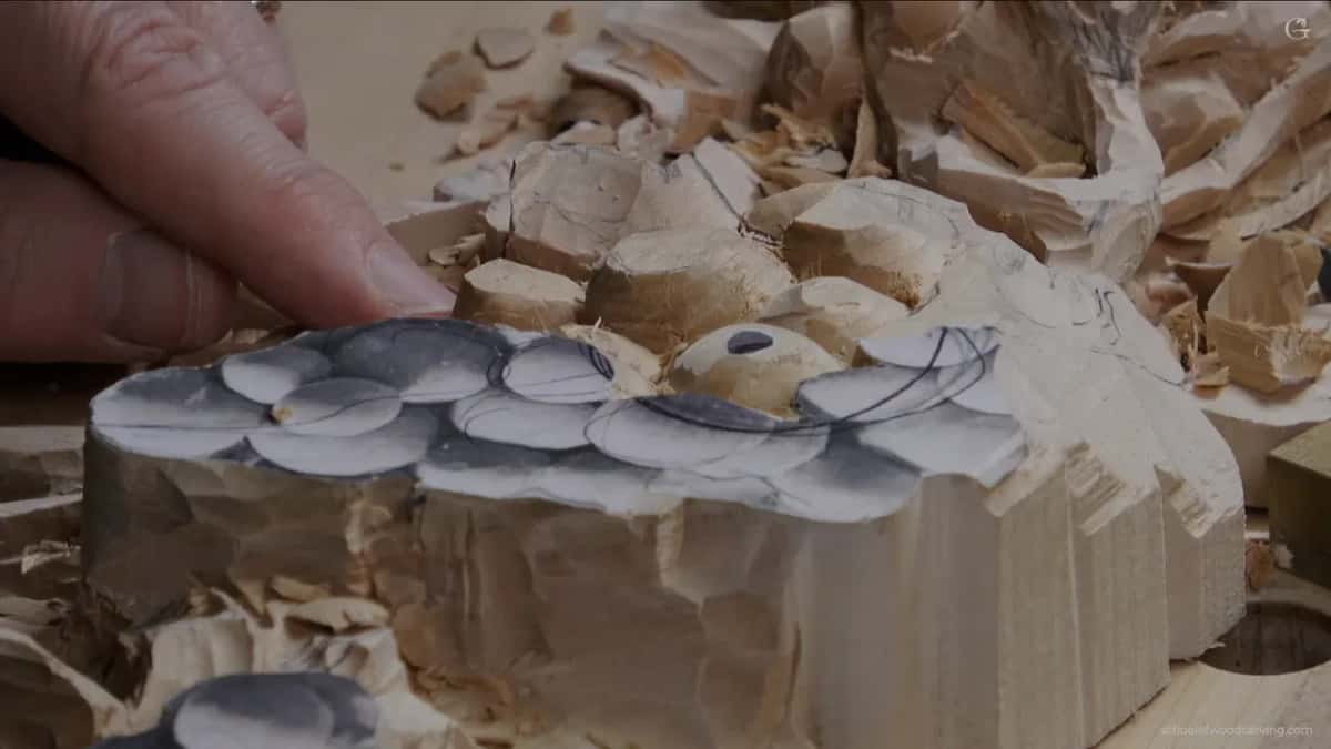 Fingertips hover over roughed grapes at the edge of the paper
