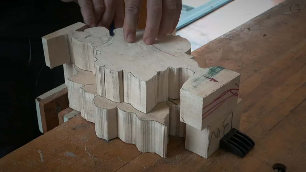 Fingers on the upper blank, a blue pencil in hand, the flat lower blank below