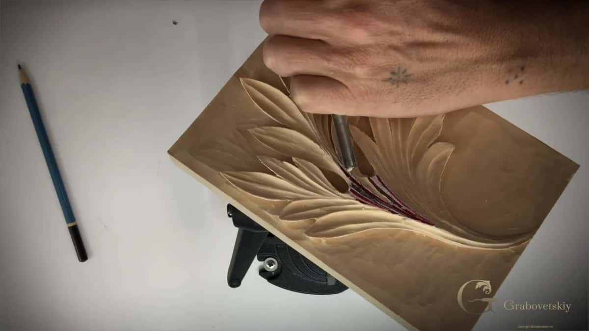 A pencil lies beside the panel as a gouge works between the red pipes.