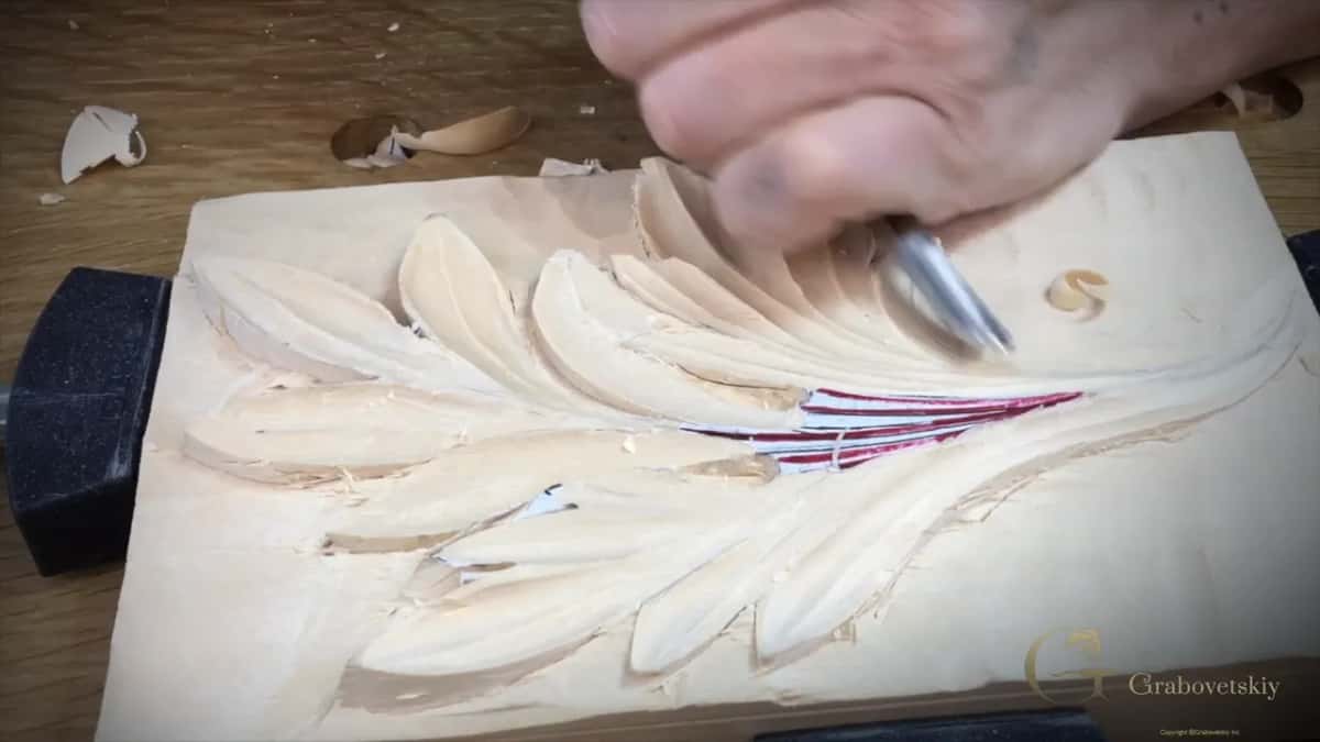 Hand driving a gouge through the top lobes next to the red stripes