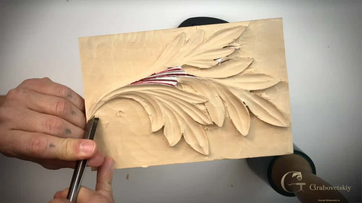 Hand guiding a tool along the left edge of the leaf