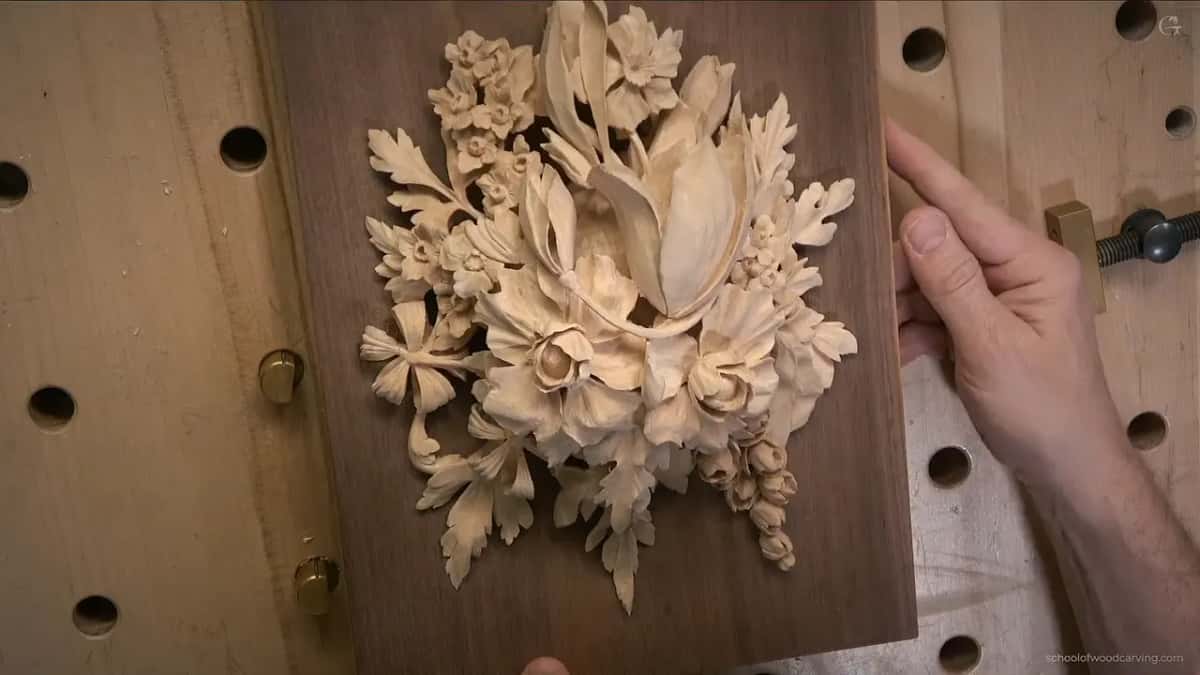 Hand steadying the board on the right, light raking across the petals