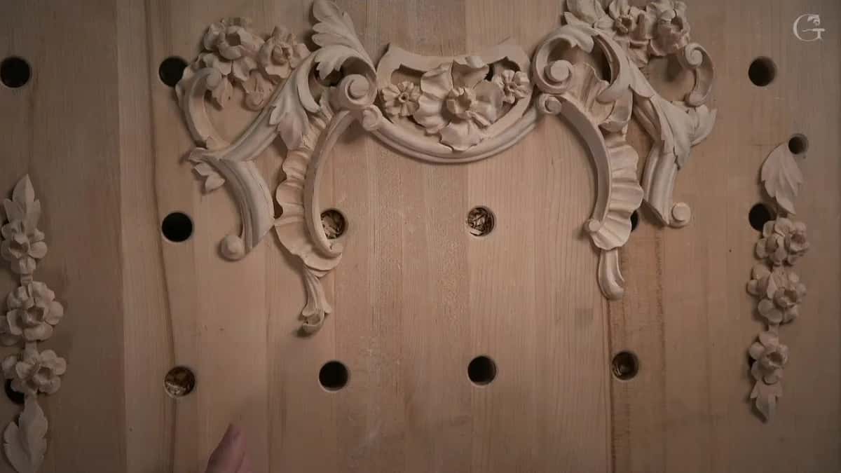 Carved scrolls, rosettes and two flower drops laid out on the bench