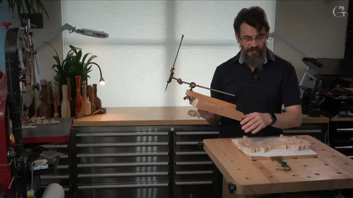Holding the pointing machine up at the bench, the sawn blank lying in front of him