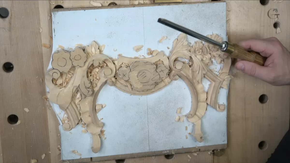 Wood handle in a right hand, the tool raised above the panel