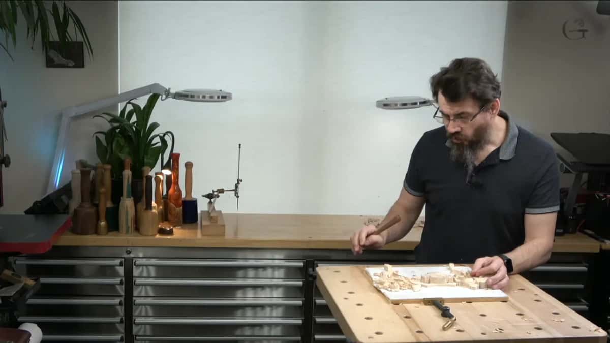 Two lamps on long arms above the back counter while he works at the front table