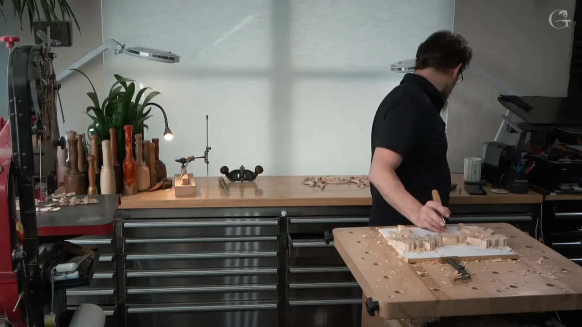 Over the panel at the near bench, with the router plane on the counter behind him