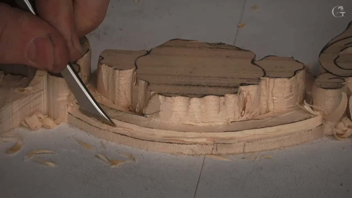 Thin curved blade at the molding's edge, shavings on the white board
