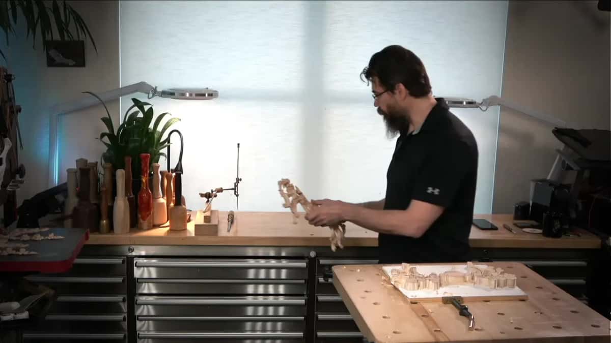 At the bench, the first carved piece in his hands
