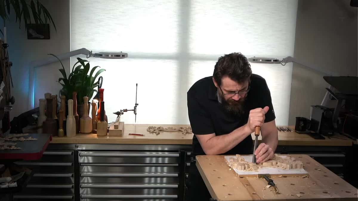 Leaning over the bench, both hands on the handle