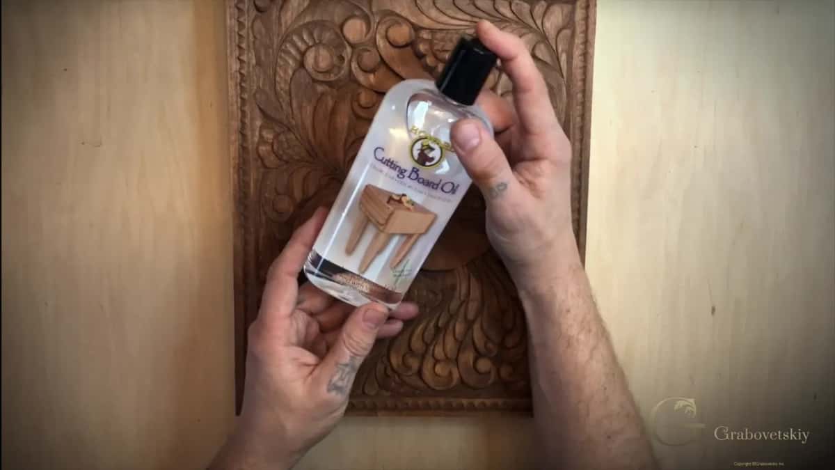 Bottle of cutting board oil held up, which is food grade mineral oil and nothing else.