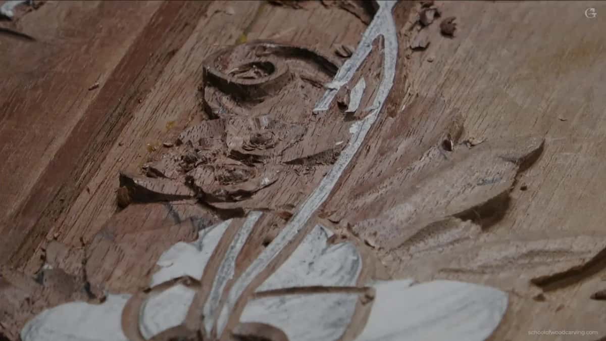 Just the carved flowers and a scroll at upper left, no hand anywhere in the frame.