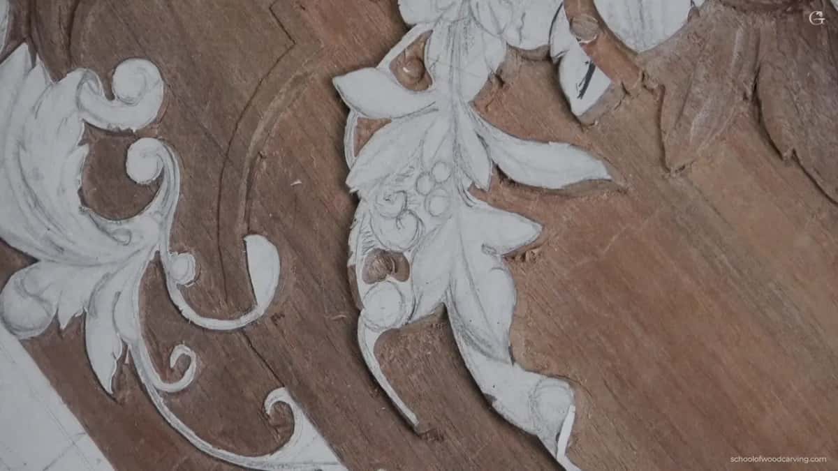 Leaves and scrolls still under the paper pattern, with small circles drawn where the berries will be