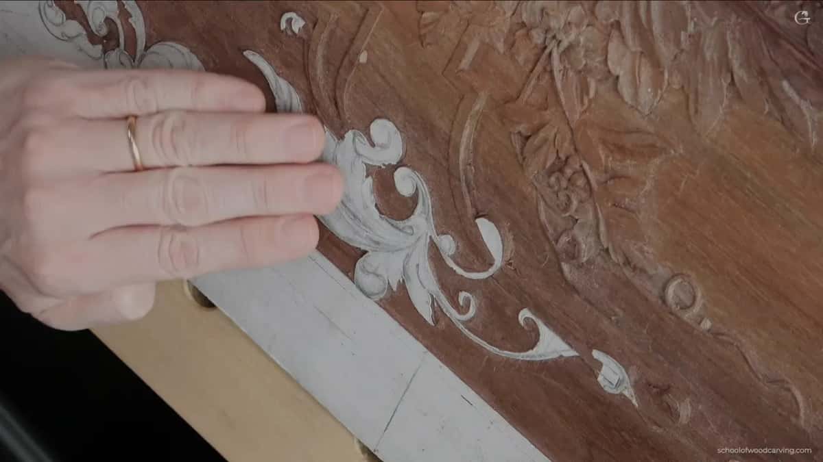 A ringed hand flat across the paper covered scrolls
