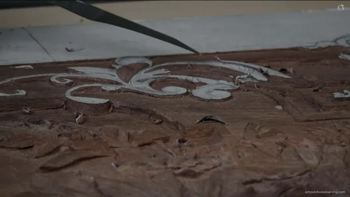 Seen low across the board, the scroll and the darker carved ground around it