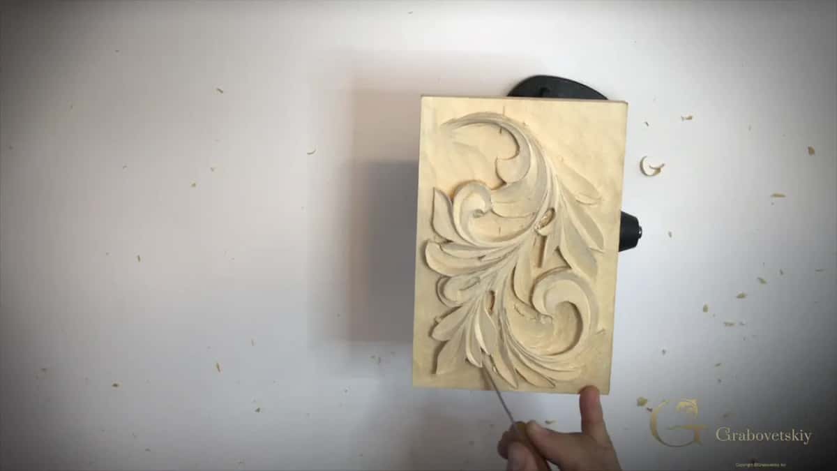 Whole panel upright, a hand and a fine tool near its foot