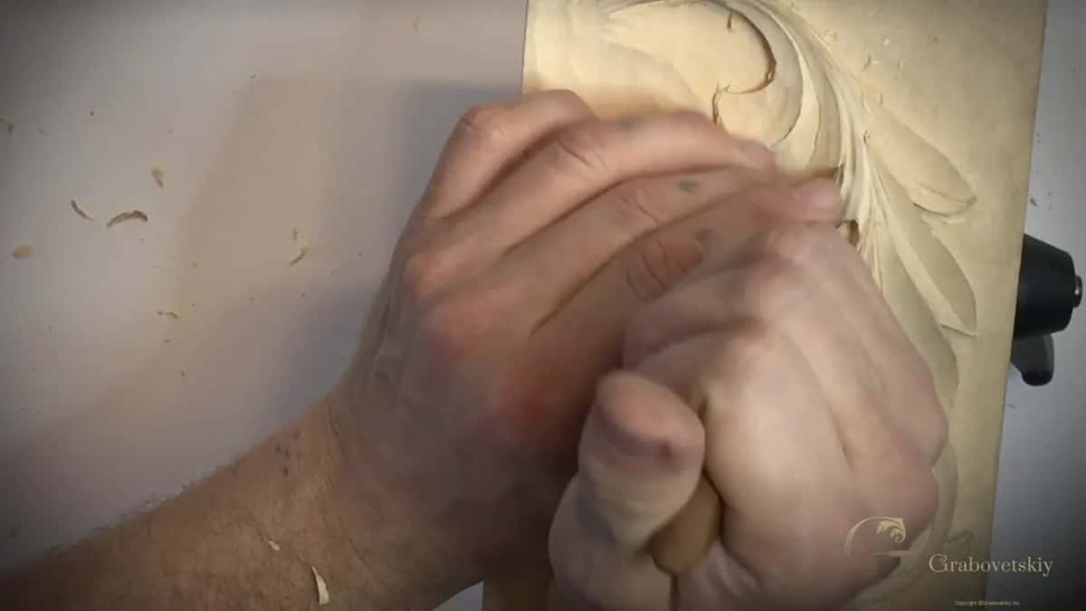 Closed hand over the carving, the blade hidden underneath it