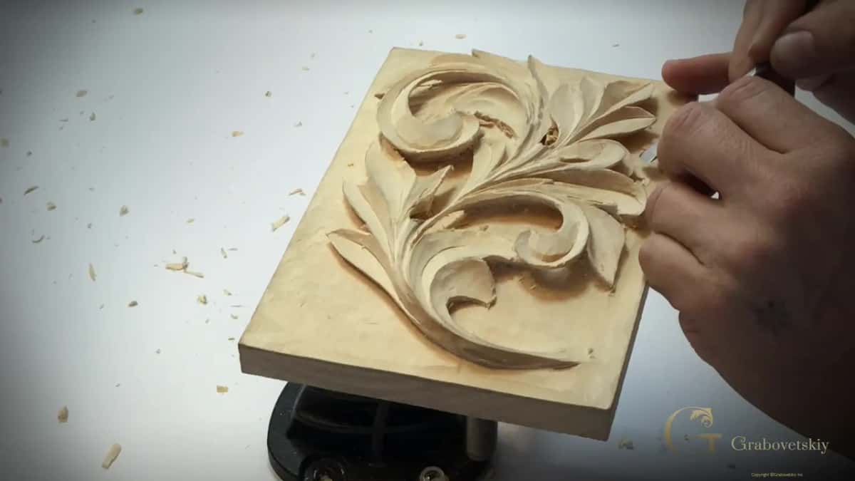Dark shade sits under the raised lobes while a hand works at the right edge of the board