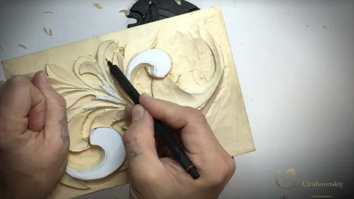 Pen tip on a lobe between the two curls